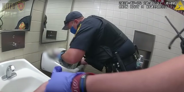 Image from bodycam shows NJ Transit Officer Bryan Richards working to save a newborn in a restroom at Newark Penn Station Tuesday.