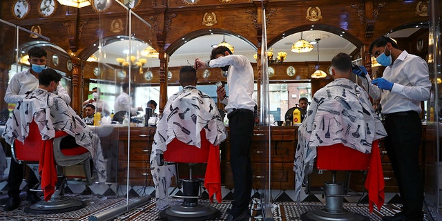 Men have their hair cut at Savvas Barbers as it reopened following the outbreak of the coronavirus disease (COVID-19), in London, Britain July 4, 2020. REUTERS/Hannah McKay - RC29MH9YHVPQ