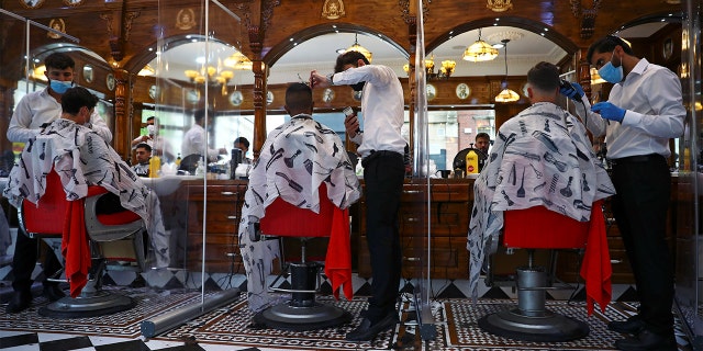 Men have their hair cut at Savvas Barbers as it reopened following the outbreak of the coronavirus disease (COVID-19), in London, Britain July 4, 2020. REUTERS/Hannah McKay - RC29MH9YHVPQ