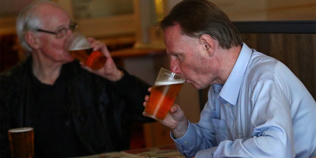 Customers drink beer at The Holland Tringham Wetherspoons pub after it reopened following the outbreak of the coronavirus disease (COVID-19), in London, Britain July 4, 2020. REUTERS/Hannah McKay - RC2AMH9ARMHE