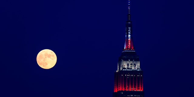 The moon rises past the Empire State Building before Macy's Fourth of July Fireworks Spectacular on July 4, 2020 in New York City.