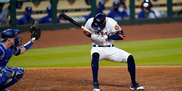 Houston Astros' Carlos Correa, right, ducks from a pitch thrown by Los Angeles Dodgers relief pitcher Joe Kelly as catcher Will Smith reaches for the ball during the sixth inning of a baseball game Tuesday, July 28, 2020, in Houston. Both benches emptied after the inning. (AP Photo/David J. Phillip)