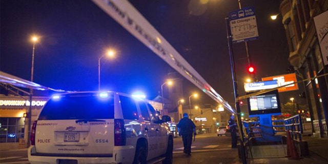 Chicago police officers investigate a crime scene of a gunshot victim.  (REUTERS/Jim Young)