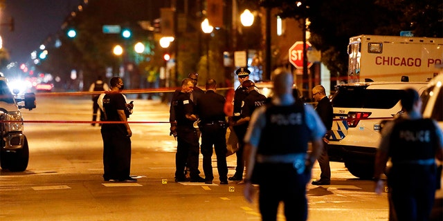 Chicago Police officers investigate the scene of a shooting in Chicago outside a funeral left 15 people wounded. (Photo by KAMIL KRZACZYNSKI/AFP via Getty Images)