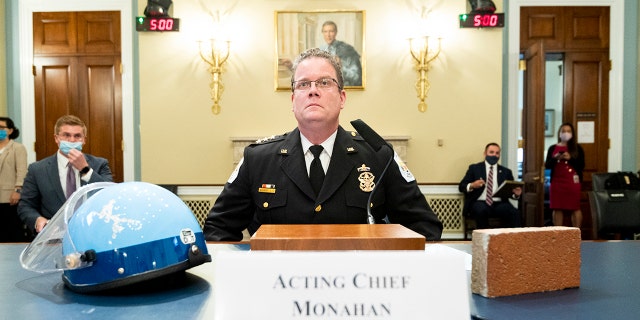 Acting U.S. Park Police Chief Gregory T. Monahan, testifies before a House Natural Resources Committee hearing on actions taken on June 1, 2020 at Lafayette Square, Tuesday, July 28, 2020 on Capitol Hill in Washington. He sits with a helmet of one of the officers who was injured by a violent protester who threw a brick at his head. (Bill Clark/Pool via AP)