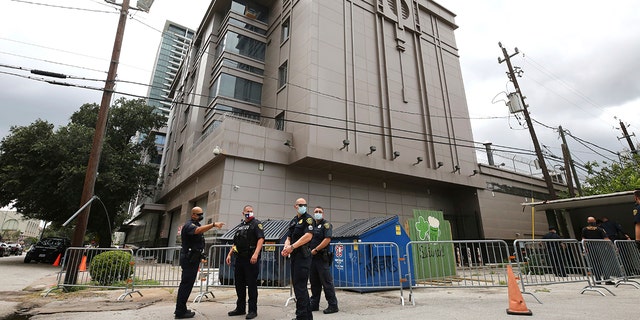 Police officers install barricades outside the Consulate General of China Friday, July 24, 2020, in Houston. Workers at China's consulate loaded up moving trucks Friday ahead of an afternoon deadline to shut down the facility, as ordered by the Trump administration. (Godofredo Vasquez/Houston Chronicle via AP)