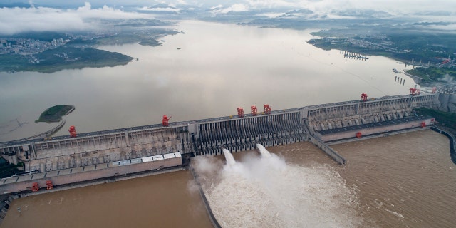 In this photo released by China's Xinhua News Agency, water flows out from sluiceways at the Three Gorges Dam on the Yangtze River near Yichang in central China's Hubei Province, Friday, July 17, 2020.