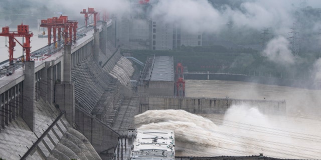 In this photo released by China's Xinhua News Agency, water flows out from sluiceways at the Three Gorges Dam on the Yangtze River near Yichang in central China's Hubei Province, Friday, July 17, 2020.