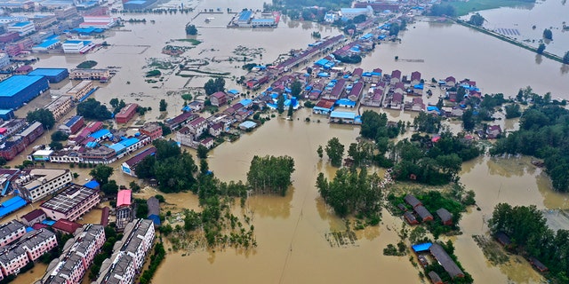In this photo released by Xinhua News Agency, an aerial photo shows the extent of flooding in Guzhen Town of Lu'an City in eastern China's Anhui Province on July 20.