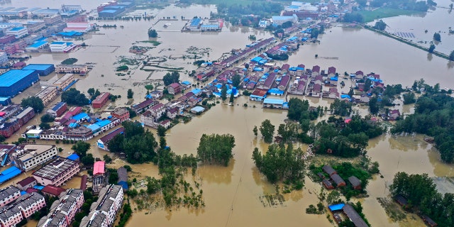 In this photo released by Xinhua News Agency, an aerial photo shows the extent of flooding in Guzhen Town of Lu'an City in eastern China's Anhui Province on July 20.