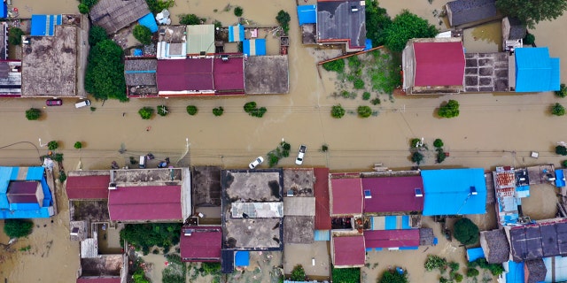 In this photo released by Xinhua News Agency, an aerial photo shows the extent of flooding in Guzhen Town of Lu'an City in eastern China's Anhui Province on July 20.