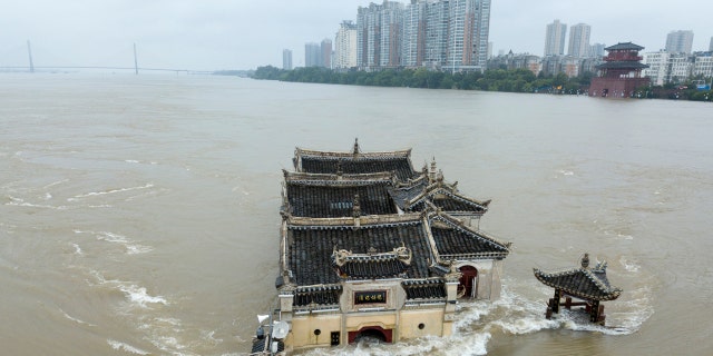 The Kwanyin temple built on a rocky island in the middle of the Yangtze River is seen flooded as the water level surge along Ezhou in central China's Hubei province on Sunday, July 19, 2020.