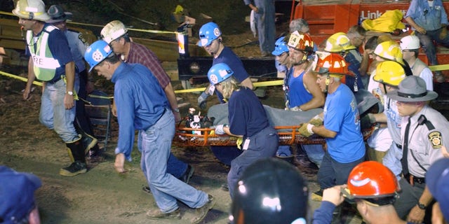 Pennsylvania Gov. Mark Schweiker, left, helps carry out the last of the trapped miners at the Quecreek Mine in Somerset, Pa., Sunday July 28, 2002. (AP Photo/Steve Helber/POOL)