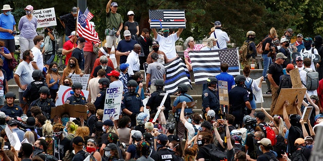 Supporters of law enforcement officers stage a rally in Denver and are confronted by counter-protesters demonstrating against racial inequality.