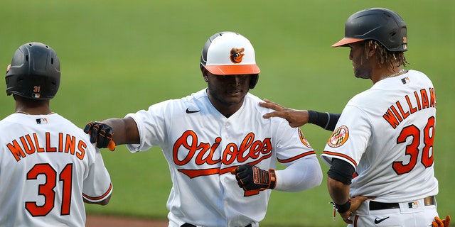 Baltimore Orioles' Dilson Herrera, center, is greeted by Cedric Mullins, left, and Mason Williams after he hit a three-run home run during an intrasquad game at baseball training camp Tuesday, July 14, 2020, in Baltimore. (AP Photo/Julio Cortez)