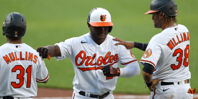 Baltimore Orioles' Dilson Herrera, center, is greeted by Cedric Mullins, left, and Mason Williams after he hit a three-run home run during an intrasquad game at baseball training camp Tuesday, July 14, 2020, in Baltimore. (AP Photo/Julio Cortez)