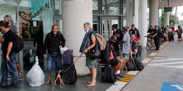 Evacuees wait to be screened prior to entry into the Hawai'i Convention Centerâ€”an American Red Cross shelter set up in advance of Hurricane Douglas, Sunday, July 26, 2020, in Honolulu.