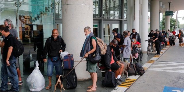 Evacuees wait to be screened prior to entry into the Hawai'i Convention Center—an American Red Cross shelter set up in advance of Hurricane Douglas, Sunday, July 26, 2020, in Honolulu.