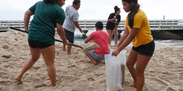 The Keo family assisted the Aubrey family with sandbagging for the preparation of Hurricane Douglas in Hauula, Hawaii, on Sunday, July 26, 2020.