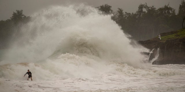 A surfer takes on a wave generated by Hurricane Douglas at Laie Beach Park, Sunday, July 26, 2020, in Laie, Hawaii.