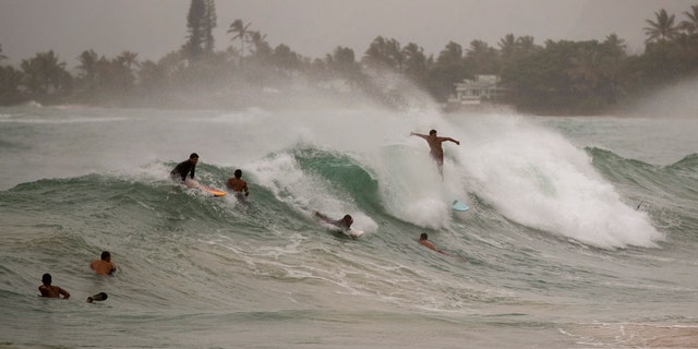 Surfers take on large waves generated by Hurricane Douglas at Laie Beach Park, Sunday, July 26, 2020, in Laie, Hawaii.