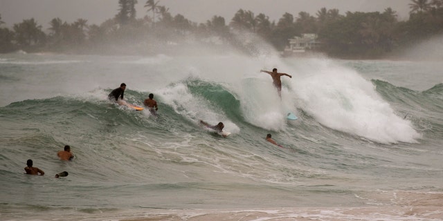 Surfers take on large waves generated by Hurricane Douglas at Laie Beach Park, Sunday, July 26, 2020, in Laie, Hawaii.