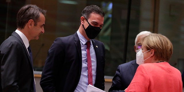 German Chancellor Angela Merkel, second right, speaks with, from left, Greek Prime Minister Kyriakos Mitsotakis, Spain's Prime Minister Pedro Sanchez and Portugal's Prime Minister Antonio Costa during a round table meeting at an EU summit in Brussels, Tuesday, July 21, 2020. Weary European Union leaders finally clinched an unprecedented budget and coronavirus recovery fund early Tuesday, finding unity after four days and as many nights of fighting and wrangling over money and power in one of their longest summits ever. (Stephanie Lecocq, Pool Photo via AP)