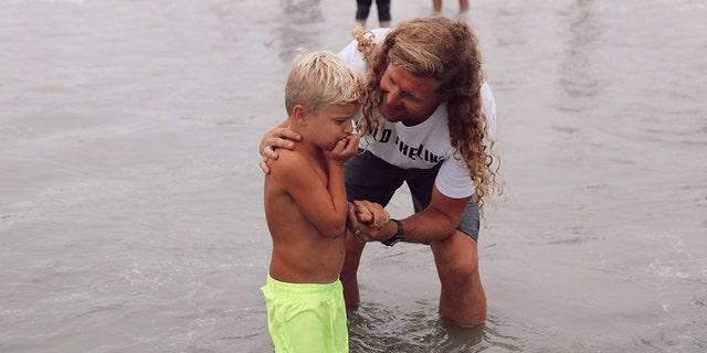 Sean Feucht baptizes his son, Ezra, at the beach.