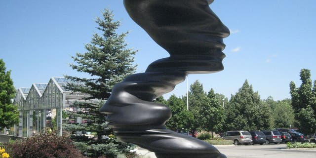 The 15-foot bronze sculpture, "Bent of Mind," by Tony Cragg, graces the entrance to Frederik Meijer Gardens and Sculpture Park in Grand Rapids, Mich.