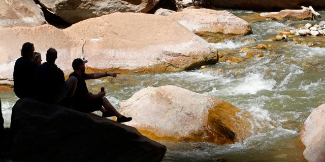 Hikers take a break along the North Fork of the Virgin River in Zion National Park on May 15 in Springdale, Utah.