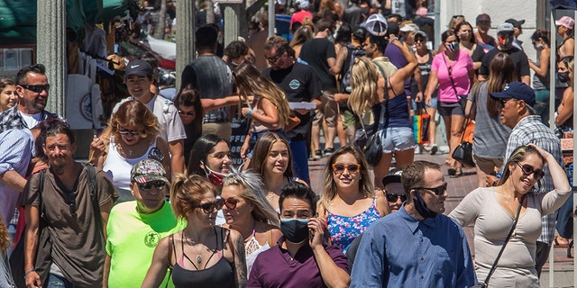 People cross the street in Huntington Beach, Calif., on July 19, 2020, amid the coronavirus pandemic. (APU GOMES/AFP via Getty Images)