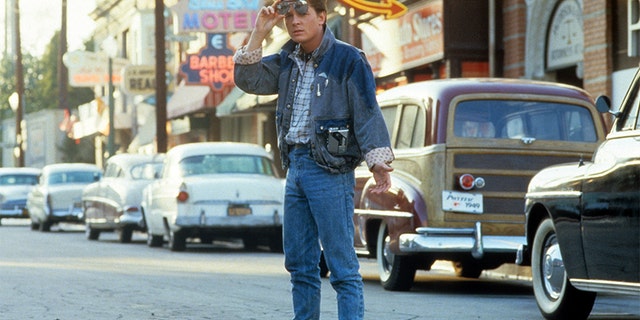 Michael J Fox walking across the street in a scene from the film 'Back To The Future', 1985.