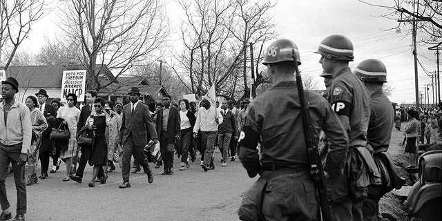 Federal Army troops guard civil rights marchers along Route 80, the Jefferson Davis Highway, during the Selma to Montgomery march on March 25, 1965 in Montgomery, Ala.