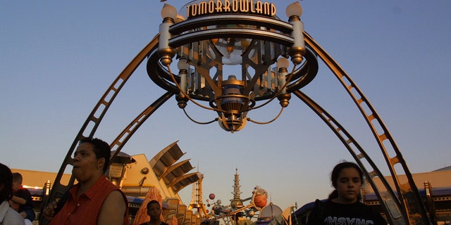 In this file photo, visitors walk through Tomorrowland in Walt Disney World's Magic Kingdom.
