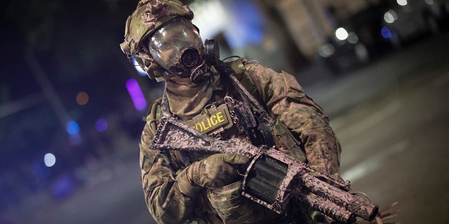 A federal officer holds a tear gas rifle during a Black Lives Matter protest at the Mark O. Hatfield U.S. Courthouse early Sunday, July 26, 2020, in Portland, Ore. (AP Photo/Marcio Jose Sanchez)