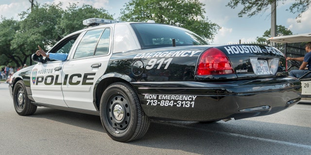 Houston, Texas, USA. 11th May 2013. Houston police car at Houston art car parade with American flags on the background. 