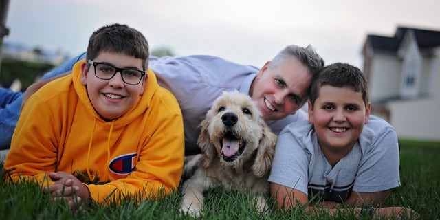 Jason Wright and his sons posing with family dog Pilgrim in last photoshoot before he passed