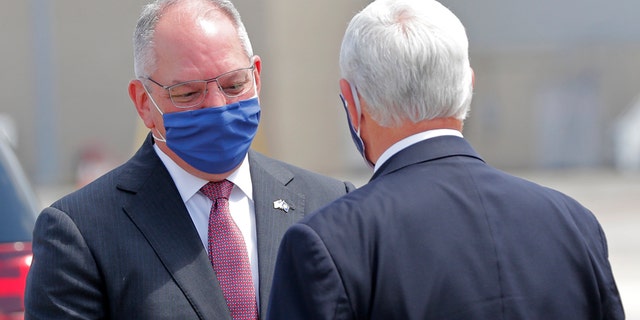 Louisiana Gov. John Bel Edwards greets Vice President Mike Pence as he arrives in Baton Rouge, La., Tuesday, July 14, 2020. (AP Photo/Gerald Herbert)