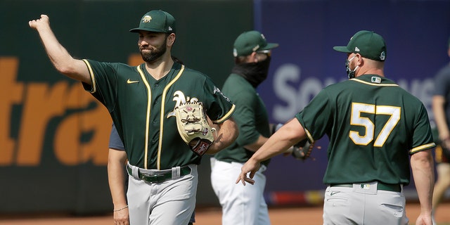 Oakland Athletics pitcher Lou Trivino, left, warms up during baseball practice Wednesday, July 15, 2020, in Oakland, Calif. (AP Photo/Ben Margot)