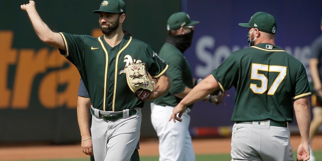 Oakland Athletics pitcher Lou Trivino, left, warms up during baseball practice Wednesday, July 15, 2020, in Oakland, Calif. (AP Photo/Ben Margot)