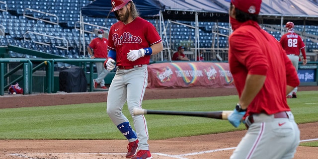 Philadelphia Phillies' Bryce Harper comes home for his three-run homer during the second inning of an exhibition baseball game against the Washington Nationals at Nationals Park, Saturday, July 18, 2020, in Washington. The Phillies won 7-2. (AP Photo/Alex Brandon)