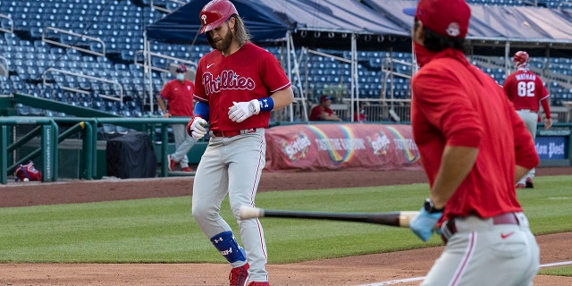 Philadelphia Phillies' Bryce Harper comes home for his three-run homer during the second inning of an exhibition baseball game against the Washington Nationals at Nationals Park, Saturday, July 18, 2020, in Washington. The Phillies won 7-2. (AP Photo/Alex Brandon)