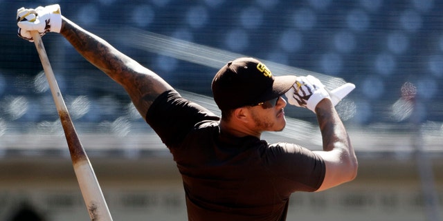 FILE - In this July 8, 2020, file photo, San Diego Padres third baseman Manny Machado bats during baseball training at Petco Park in San Diego. Machado has vowed to play better than he did during his first season after signing a $300 million, 10-year deal. (AP Photo/Gregory Bull,File)