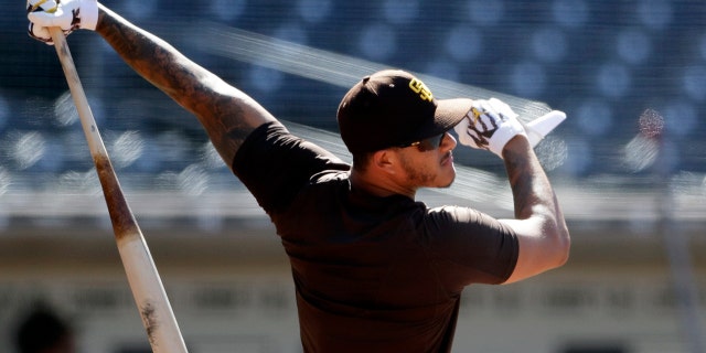 FILE - In this July 8, 2020, file photo, San Diego Padres third baseman Manny Machado bats during baseball training at Petco Park in San Diego. Machado has vowed to play better than he did during his first season after signing a $300 million, 10-year deal. (AP Photo/Gregory Bull,File)