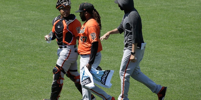 San Francisco Giants' Chadwick Tromp, left, walks with Johnny Cueto, center, and another player during baseball practice in San Francisco, Tuesday, July 14, 2020. (AP Photo/Jeff Chiu)