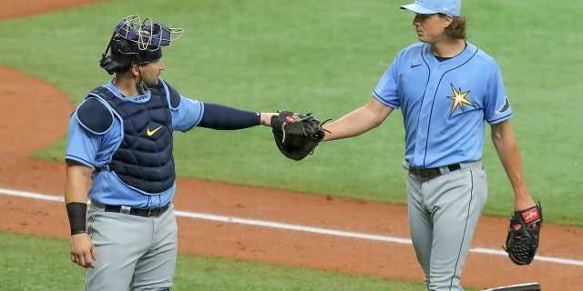 Tampa Bay Rays' Tyler Glasnow, right, bumps fists with catcher Mike Zunino after pitching during baseball practice Tuesday, July 14, 2020, in St. Petersburg, Fla. (AP Photo/Mike Carlson)