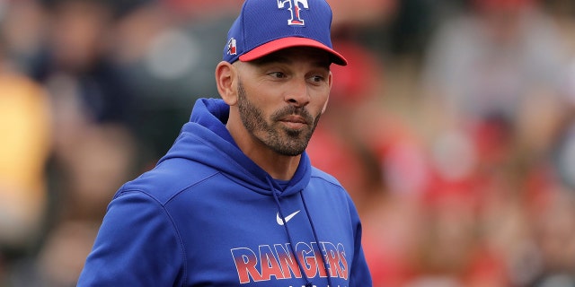 FILE - In this Friday, Feb. 28, 2020, file photo, Texas Rangers manager Chris Woodward walks back to the dugout after making a pitching change during the third inning of a spring training baseball game against the Los Angeles Angels, in Tempe, Ariz. (AP Photo/Charlie Riedel, File)