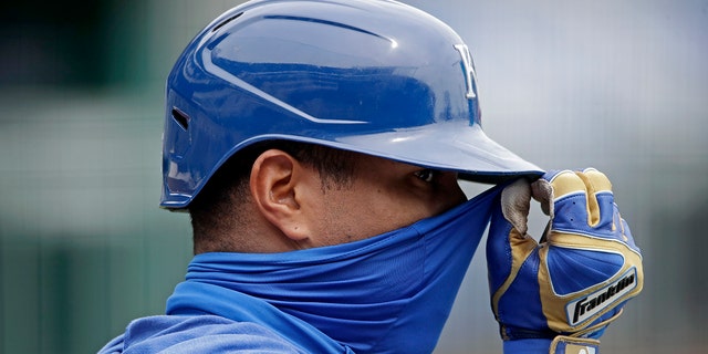 Kansas City Royals' Salvador Perez adjusts his mask during baseball practice at Kauffman Stadium, Thursday, July 16, 2020, in Kansas City, Mo. (AP Photo/Charlie Riedel)