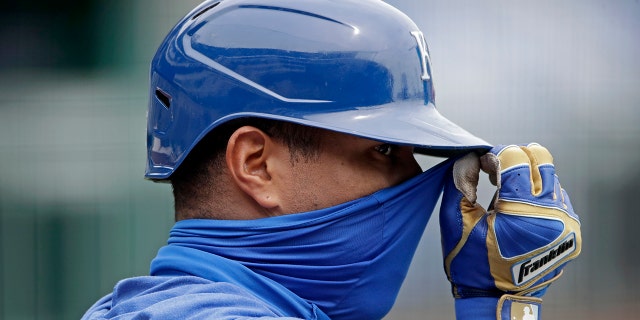 Kansas City Royals' Salvador Perez adjusts his mask during baseball practice at Kauffman Stadium, Thursday, July 16, 2020, in Kansas City, Mo. (AP Photo/Charlie Riedel)