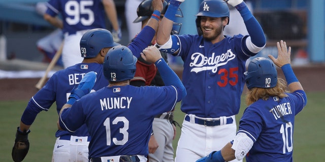 Los Angeles Dodgers' Cody Bellinger (35) is met at home plate after hitting a grand slam during the first inning of an exhibition baseball game against the Arizona Diamondbacks Sunday, July 19, 2020, in Los Angeles. (AP Photo/Marcio Jose Sanchez)